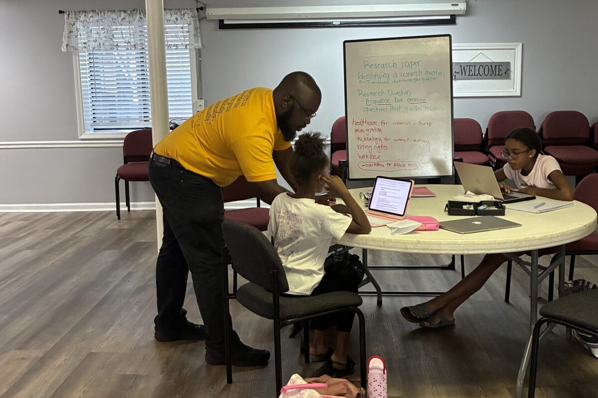 An IIA tutor guiding students through a research paper during a small-group session in Snellville, Georgia